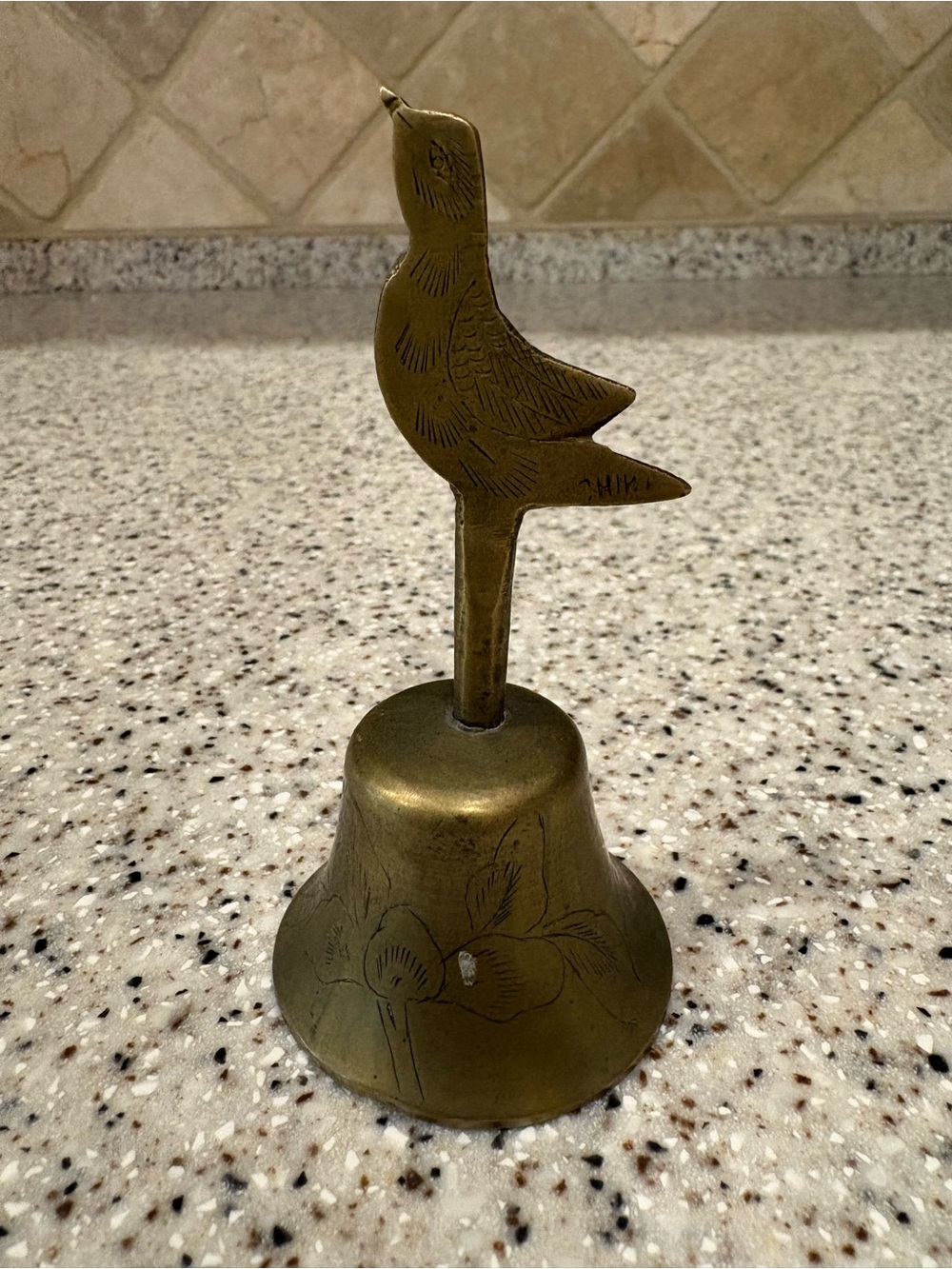 Vintage brass handbell features a small sparrow perched on top of the handle